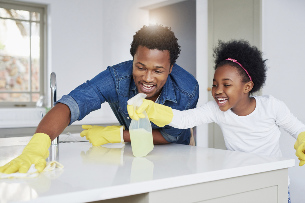 Father and daughter cleaning kitchen counters